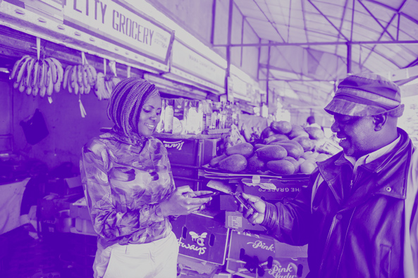 A Kenyan woman makes a mobile payment in a market