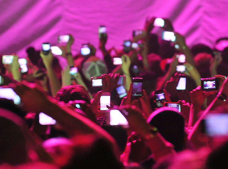 a crowd holding up their smartphones